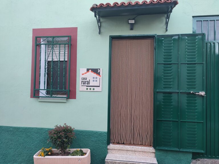 Puerta de entrada de la casa rural Regajo Lobos y jardinera con plantas