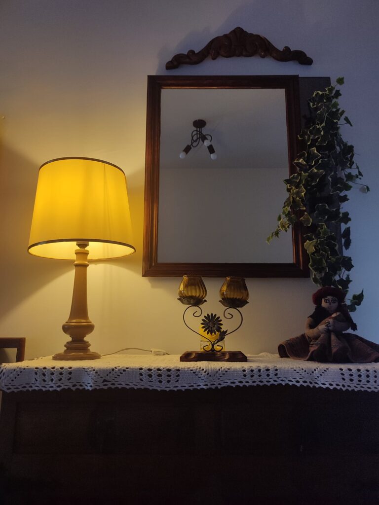 Aparador de la primera planta con lámpara y espejo en la Casa rural Regajo Lobos