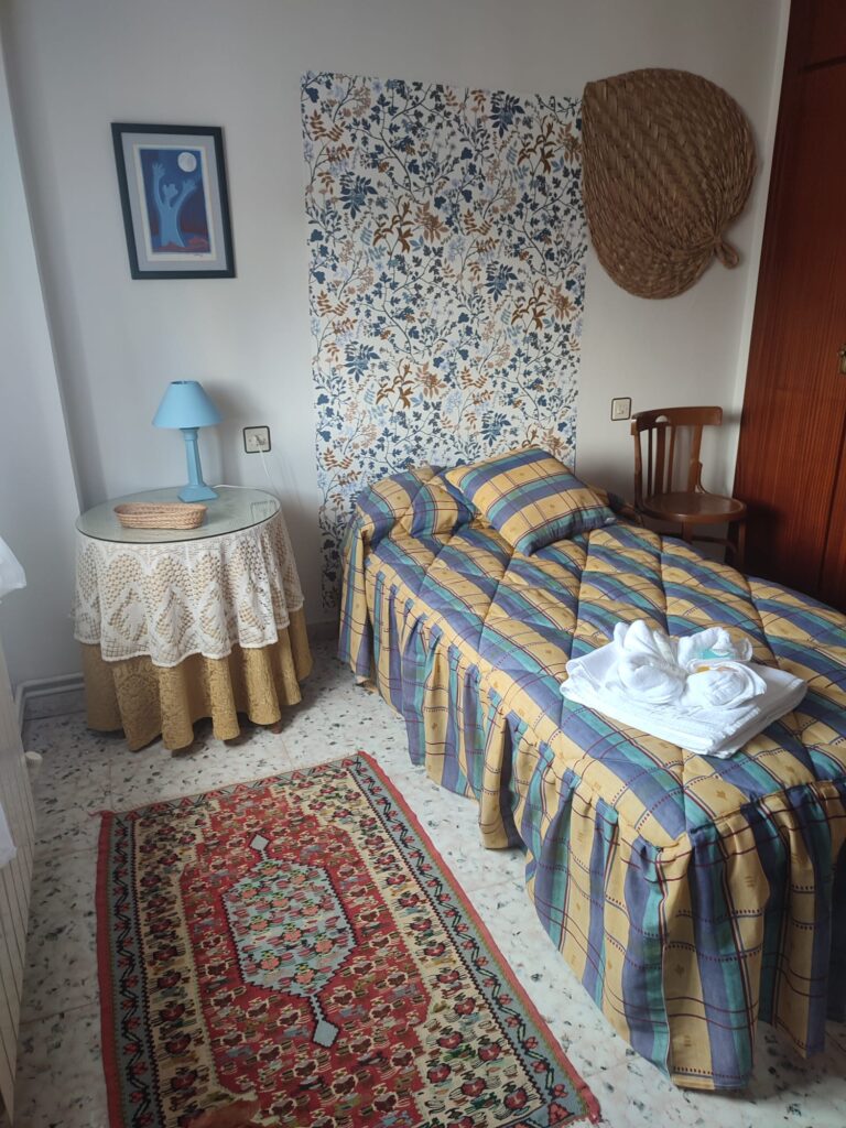 Habitación de una cama con mesita, silla y decoración en la Casa rural Regajo Lobos