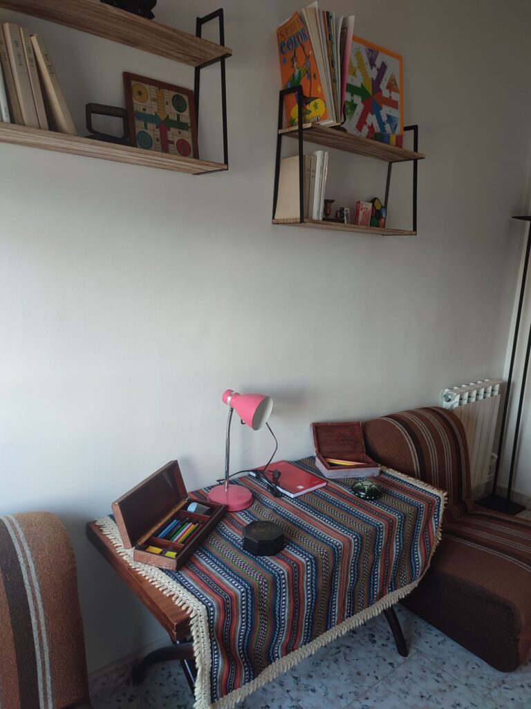 Sala de lectura. Sillones y estanterías con libros y juegos en la Casa rural Regajo Lobos