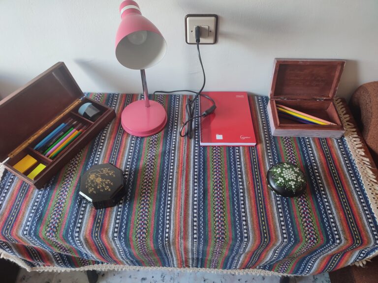 Mesa en la sala de lectura con pinturas, cuaderno, ceras. Casa rural Regajo Lobos